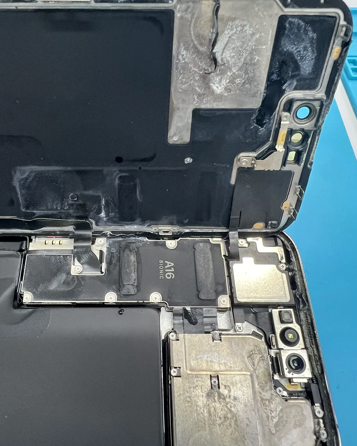 iPhone 14 Pro con restos de líquido bajo los blindajes