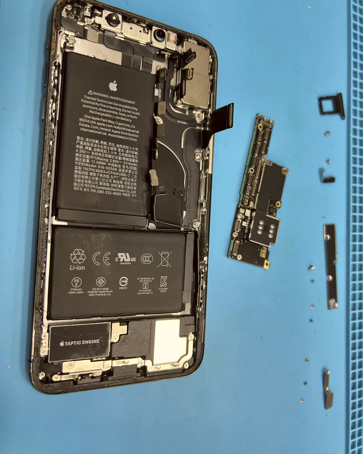 iPhone desmontado con la placa fuera del chasis