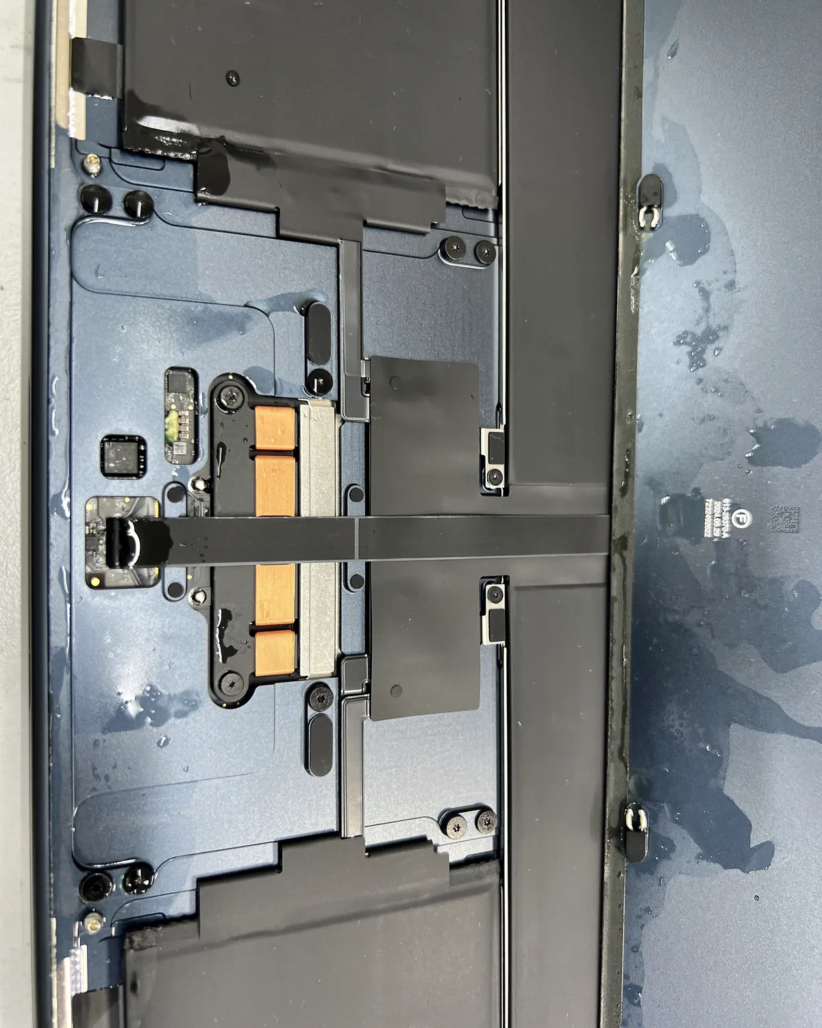 MacBook Air con líquido junto al trackpad