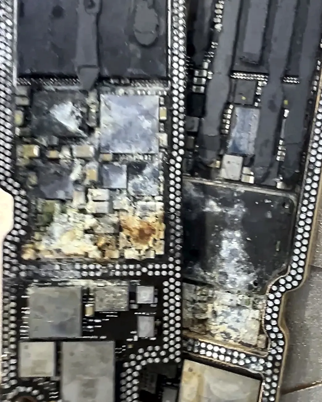 Placa de iPhone abierta en sus dos capas, con corrosión severa