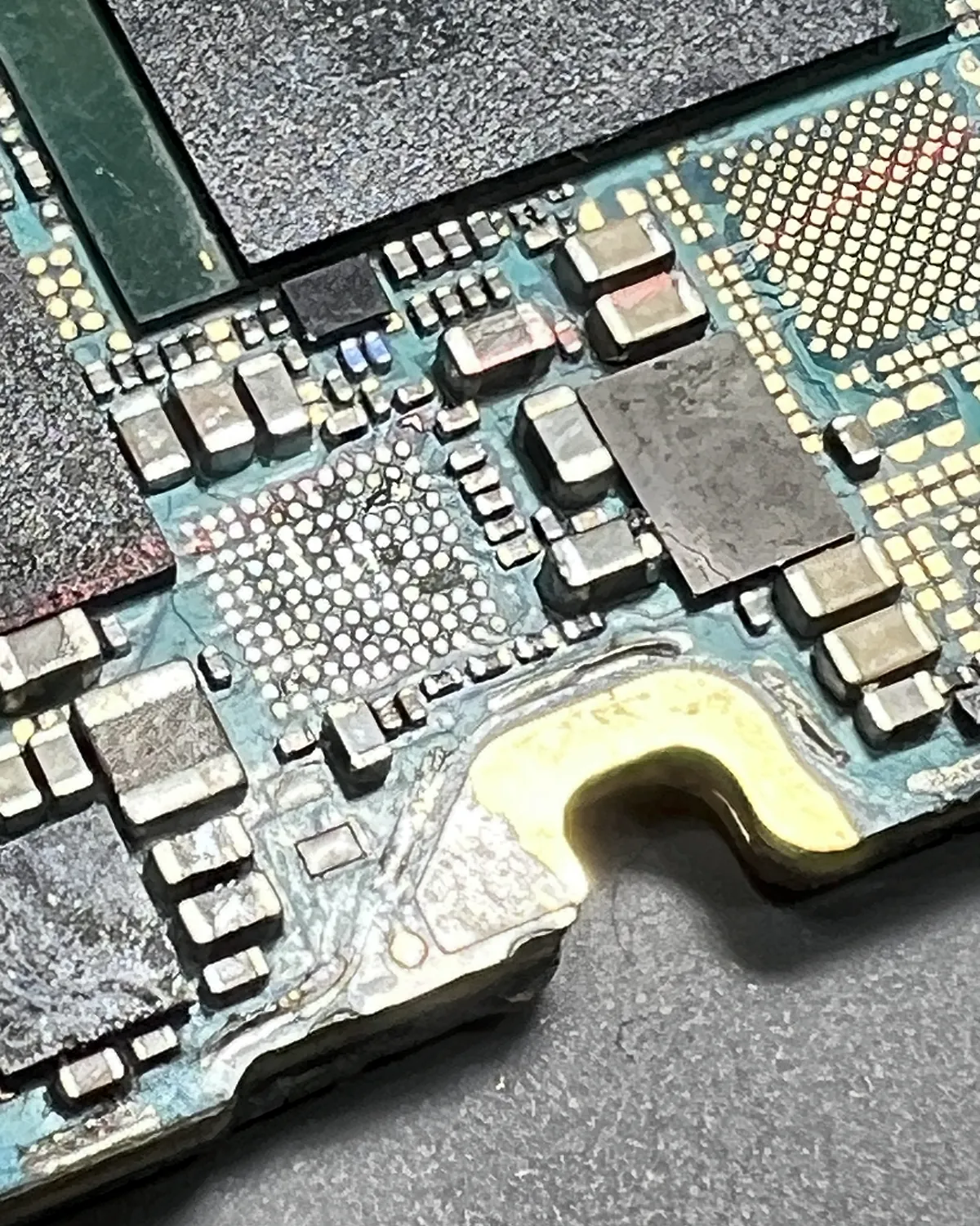 Placa de Samsung con corrosión en el borde y un chip retirado