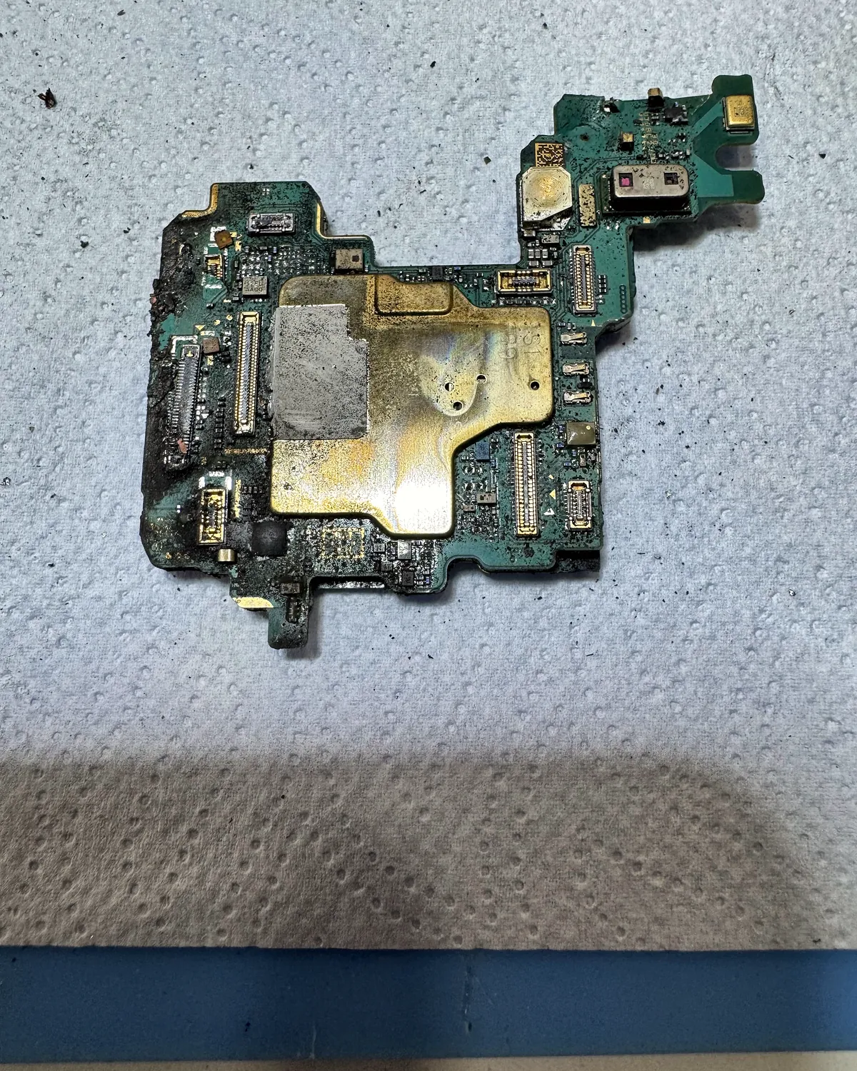Placa de Samsung Galaxy con corrosión y zonas quemadas